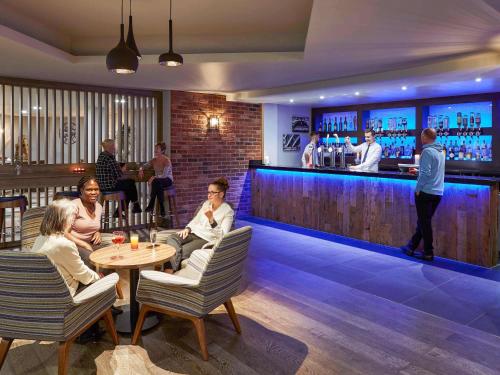 a group of people sitting at a bar at Novotel Manchester West in Worsley