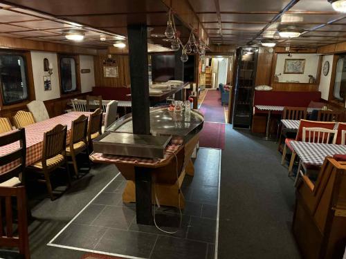 a restaurant with a bar and tables and chairs at Norwegian Fjord Explorer Line in Tromsø