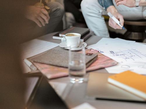 a group of people sitting around a table with a cup of coffee at ibis Orange Centre in Orange