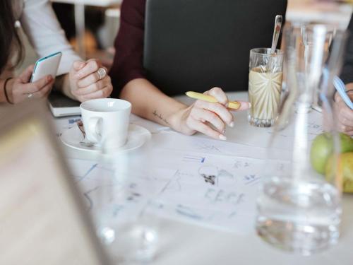 a group of people sitting at a table with a drawing at ibis Orange Centre in Orange