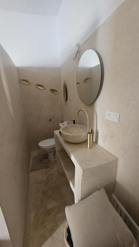 a bathroom with a sink and a mirror and a toilet at Riad Laila Marrakech in Marrakesh