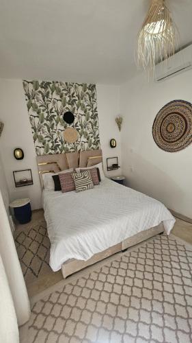 a bedroom with a large white bed with a rug at Riad Laila Marrakech in Marrakesh