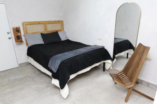 a bedroom with a bed and a mirror and a chair at Departamento Refugio Sereno cerca de la UAS y nuevo hospital General in Culiacán