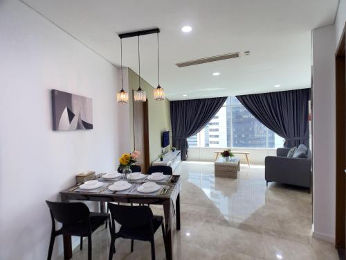 a dining room and living room with a table and chairs at Vortex Suites KLCC By GuestHouse in Kuala Lumpur