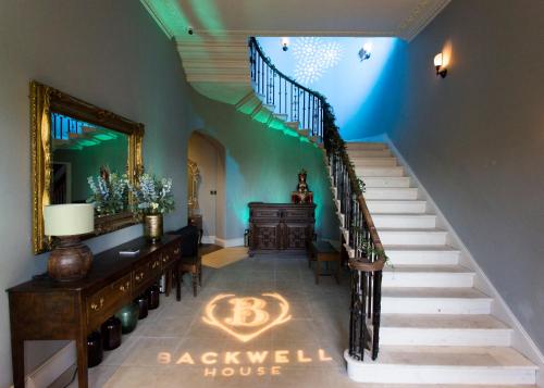 a living room with a staircase leading up to a staircase at Backwell House in Nailsea