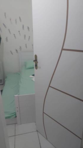 a mirror in a white bathroom with a toilet at Casa Pousadinha Mel- QUARTOS E DORMITORIOS in Salvador