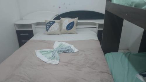 a bedroom with a bed with two towels on it at Casa Pousadinha Mel- QUARTOS E DORMITORIOS in Salvador