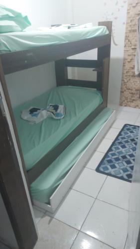 a bunk bed in a room with a green mattress at Casa Pousadinha Mel- QUARTOS E DORMITORIOS in Salvador
