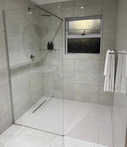 a shower with a glass door in a bathroom at Luu Luxury Suite in East London
