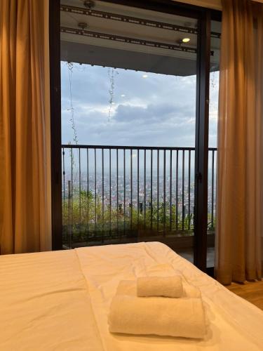 a bedroom with a bed and a large window at Oak Room Ở Space Ecopark in Kim Quan