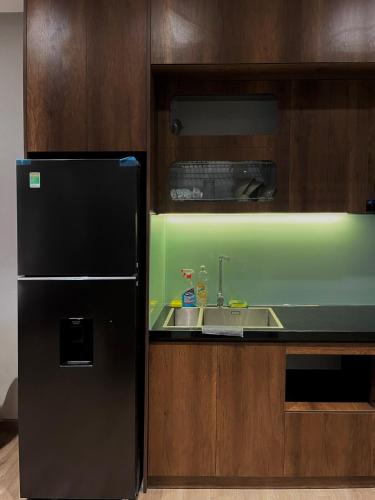 a kitchen with a black refrigerator and a sink at Oak Room Ở Space Ecopark in Kim Quan