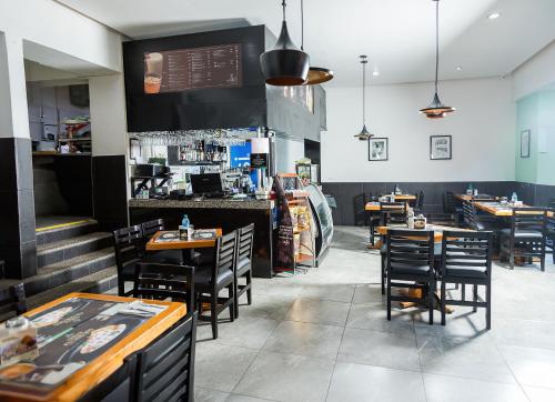 Un restaurante con mesas y sillas y un bar. en Hotel Central Teziutlan, en Teziutlán