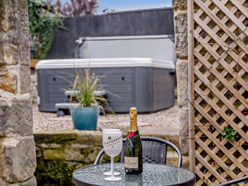 a bottle of wine sitting on a table with a glass at 2 Bed in Amble 91206 in Amble