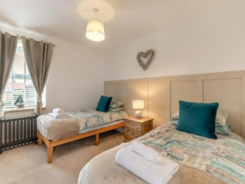 a bedroom with two beds and a window at 2 Bed in Amble 91206 in Amble