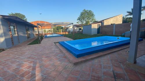 a swimming pool in a yard with a house at Alojamiento Paraíso del Parana in Carmen del Paraná
