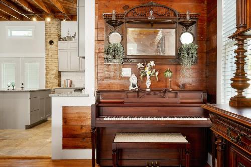 a piano in a room with a kitchen at The Bowie Grand - Historic Comfort in Seguin in Seguin