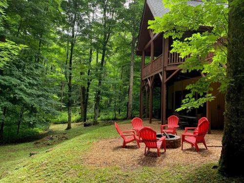 a group of red chairs sitting outside of a cabin at The Feisty Fox in Sugar Mountain
