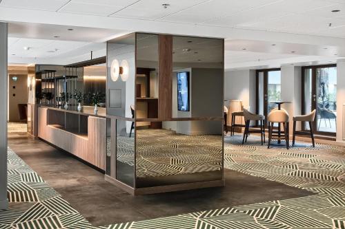 a lobby with a bar with chairs and tables at Radisson Hotel Kaunas in Kaunas