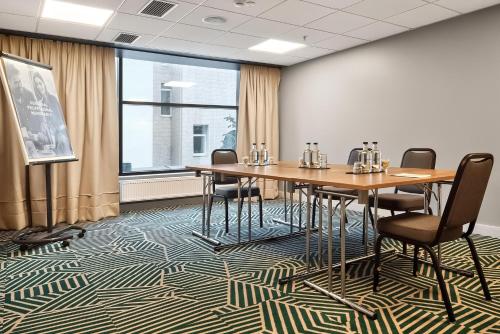 a conference room with tables and chairs and a large window at Radisson Hotel Kaunas in Kaunas