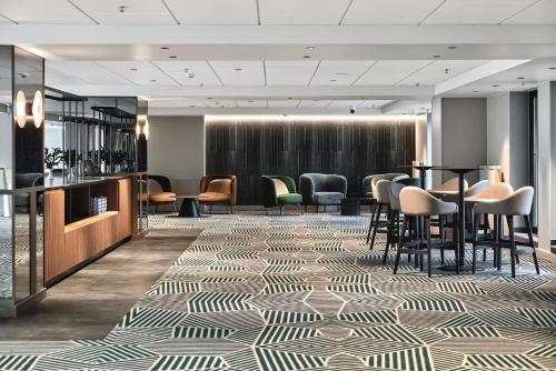 a lobby with a bar with chairs and tables at Radisson Hotel Kaunas in Kaunas