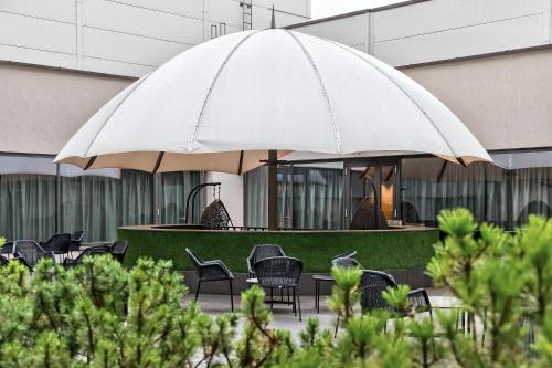 a large white umbrella in front of a building at Radisson Hotel Kaunas in Kaunas