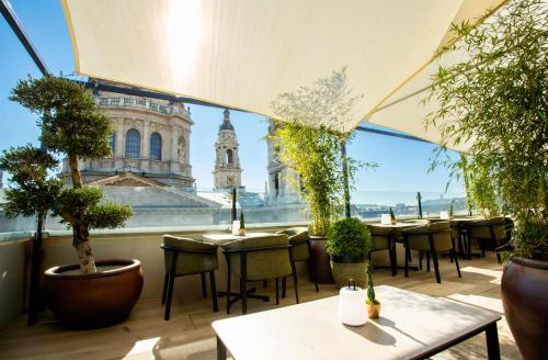 a restaurant with tables and chairs and a view of a building at Radisson Collection Hotel, Basilica Budapest in Budapest