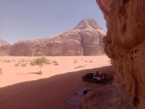 a jeep parked in the desert with a mountain at wadi rum Desert life in Disah