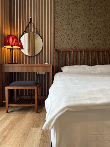 a bedroom with a bed and a table with a lamp at Mizu Room Ecopark panorama view in Kim Quan