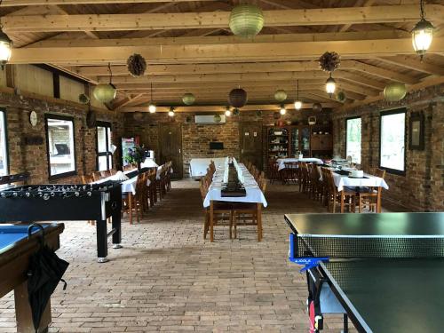 a dining room with tables and ping pong tables at Piros Tanya és Vendégház in Nyíregyháza