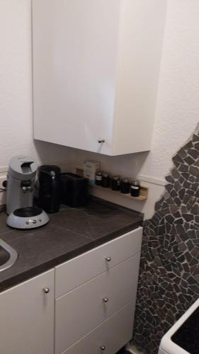 a kitchen with white cabinets and a counter top at Beas Ferienglück in Busenberg