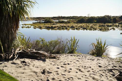a view of a body of water with a beach at Hightide River Escape -with Outdoor Bath in Hokitika