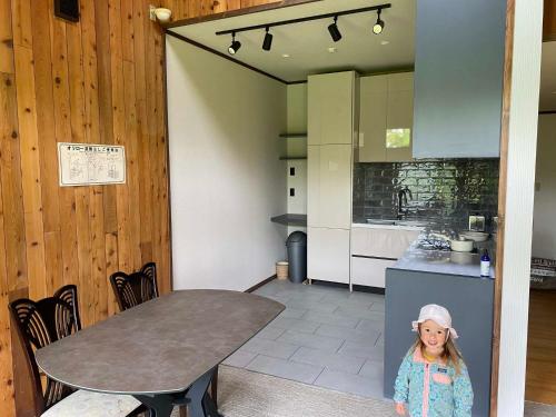a little girl standing next to a table in a kitchen at The Lakehouse at Toyako - Vacation STAY 44250v in Tōya