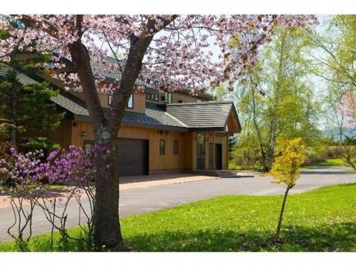 a house with a tree in front of a driveway at The Lakehouse at Toyako - Vacation STAY 44254v in Tōya