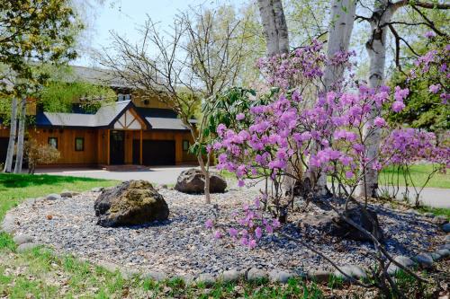 a garden with pink flowers in front of a house at The Lakehouse at Toyako - Vacation STAY 44254v in Tōya