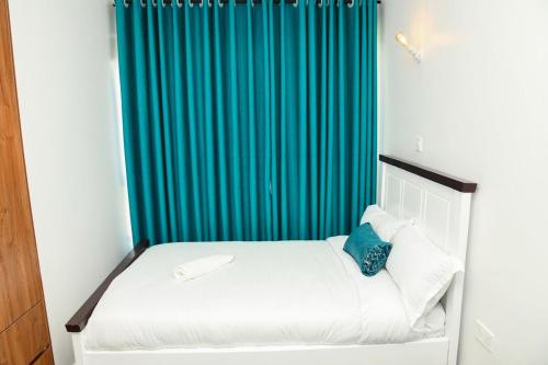 a bedroom with a bed with a blue shower curtain at comfystdkiambu in Kiambu