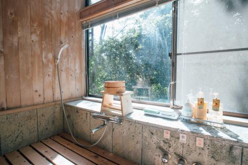 bagno con doccia e lavandino con finestra di Sakura Villa - Vacation STAY 54508v a Futo