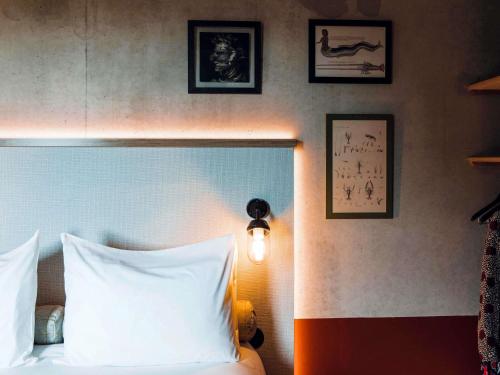 a bedroom with a bed and some pictures on the wall at ibis Styles La Rochelle Centre Gare in La Rochelle