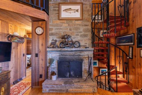 a living room with a stone fireplace and a staircase at On Any Sunday in Blowing Rock