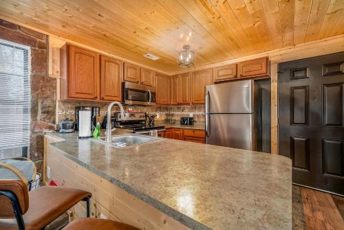Una cocina con refrigerador de acero inoxidable y gabinetes de madera. en Mountain Views at Dolly's Castle Unit 4, en Sevierville