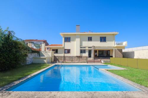 a swimming pool in front of a house at Villa 7BR & 7BA with Pool & Backyard in a Prime Location! in Vila Nova de Gaia