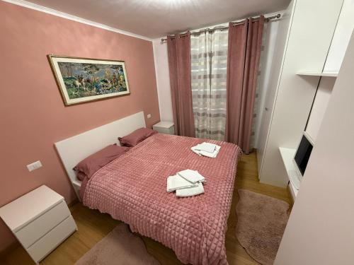 a small bedroom with a bed with two towels on it at Apartament Bibi in Făgăraş