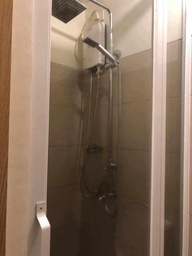 a shower in a bathroom with a glass door at Great Escape 5th FLR GARDEN VIEW in Kaybagal