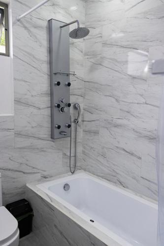 a white bath tub in a bathroom with marble walls at Brisas del Volcán BnB in Fortuna