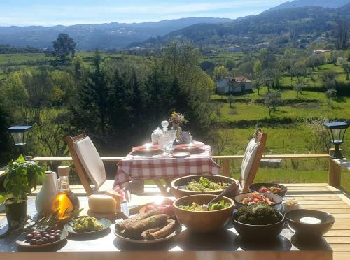 un tavolo con piatti di cibo su un tavolo con vista di Quinta de Natureza a Nabais