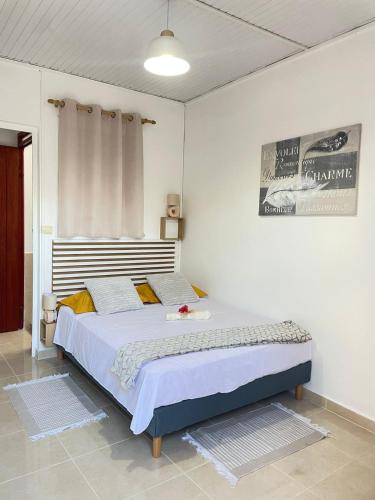 a bedroom with a large bed in a room at Soleil éclatant in Sainte-Anne