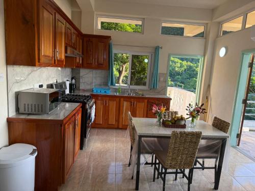 - une cuisine avec une table, une cuisinière, une table et des chaises dans l'établissement You 4 Ric Piton Suites, à Soufrière
