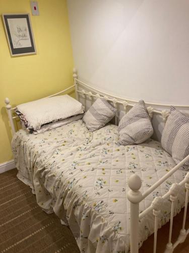 ein weißes Bett mit Kissen auf dem Zimmer in der Unterkunft Studio Annexe with separate shower room in Broadhempston