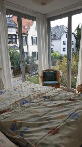a bedroom with a bed and a large window at Ferienwohnung am Römischen Haus in Weimar