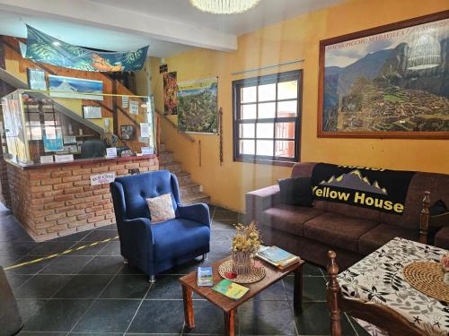 Una sala de estar con un sofá y una silla azul. en Hostel Yellow House MG, en Itamonte