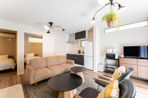 ein Wohnzimmer mit einer Couch und einem Bett in der Unterkunft S-flat Kohama - Vacation STAY 20282 in Osaka